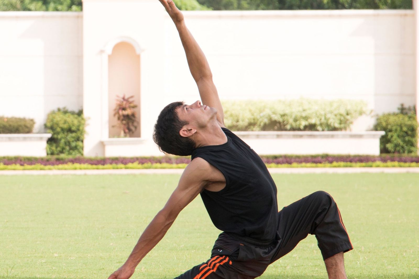 A person holding a standing yoga posture outdoors in natural light